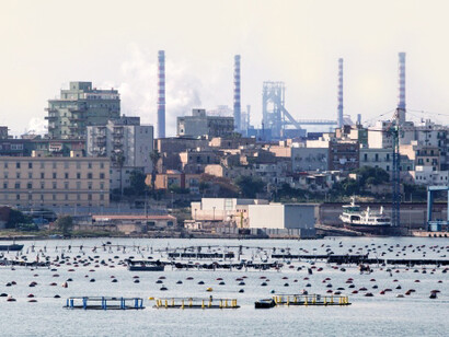 Smoke rises from the Ilva SpA steel plant in this view from the harbor of Taranto, Italy