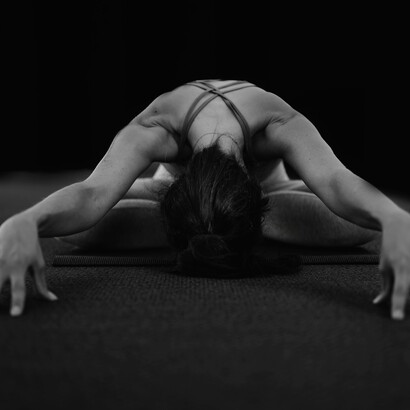 A woman practising yoga on a mat and increasing her flexibility and strength 