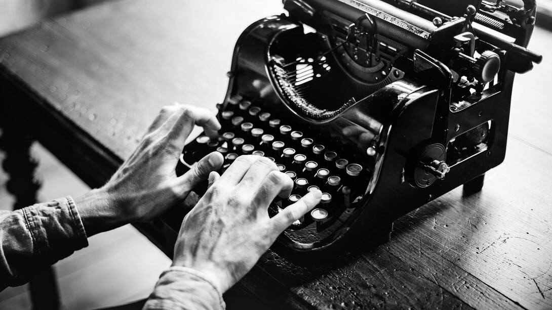Mãos no teclado, texto sob pressão: escrever é escolher o que fica — e ter coragem de cortar o resto