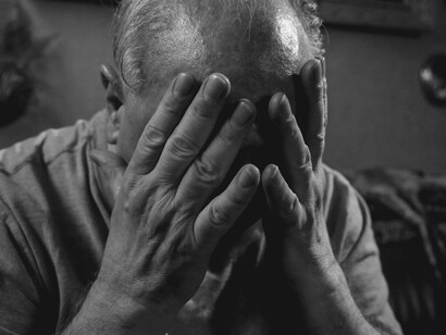Sentado e com as mãos cobrindo o rosto, um homem demonstra sofrimento emocional. O luto, a negação e a angústia são algumas das reações humanas diante da perda e da finitude