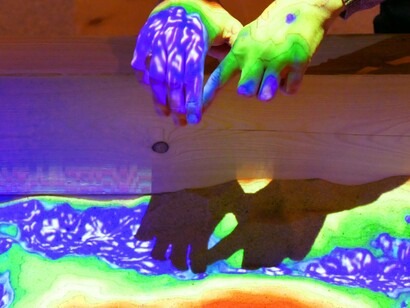 Desenvolvedores da Wikimedia no Ars Electronica Center em Linz, Áustria, brincando com um mapa topográfico em caixa de areia de realidade aumentada. Um dos grandes desafios na educação infantil é ensinar conceitos abstratos de forma clara e acessível. A RA supera essa barreira ao criar conexões visuais entre o mundo físico e digital. Por exemplo, uma atividade de ciências pode usar RA para mostrar o ciclo da água em animações tridimensionais, permitindo que as crianças vejam como a evaporação, a condensação e a precipitação ocorrem