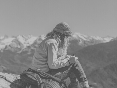 Journaling in a mountainous region after a successful hike checks two boxes, body movement and expressing your soul for self-love 