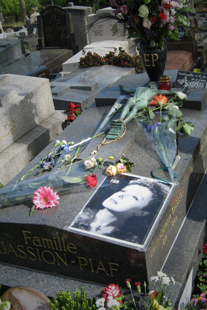 È un luogo in cui la morte non cancella, ma scolpisce la memoria nei gesti quotidiani dei visitatori. Nella foto la tomba di Edith Piaf. Cimitero di Père-Lachaise, Parigi, Francia