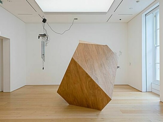 Graham Gussin, Exhibition View with Contraption, 2014, Wind chime and distortion unit tuned to the first bar of Master of the Universe, metal grille, ice hockey puck, fan, motion sensor, sound equipment, 230 x 43 x 18 cm Unique
