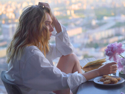 A solitary figure seated by a window with an untouched cookies and open book, symbolising emotional disconnection in a hyper-connected world