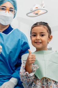 Dentist and young girl give a thumbs-up 