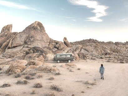 Mujer se dirige a su vehículo para continuar el camino en Alabama Hills, EE.UU.