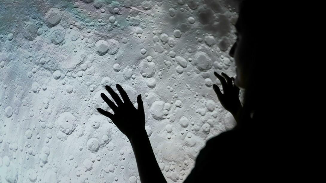 A woman examines a picture of the moon's surface