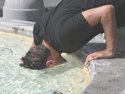 Hombre sumerge la cabeza en una fuente durante una de las olas de calor que azotaron Europa en 2023