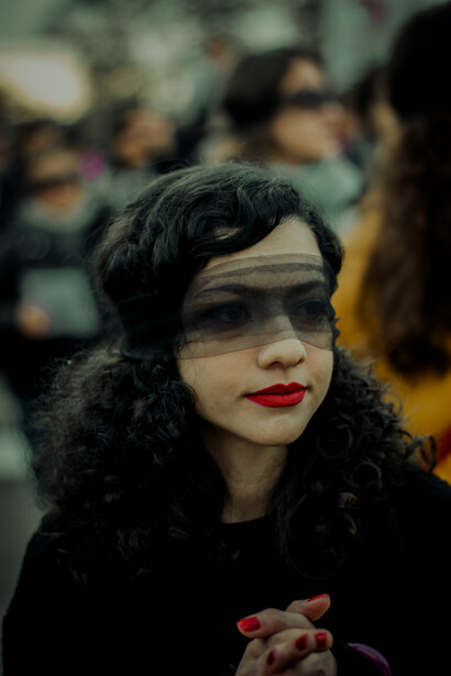 A woman wearing a transparent blindfold screams on a city street