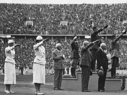 Pessoas fazendo a saudação nazista em uma entrega de medalhas no Estádio Olímpico de Berlim em 1936