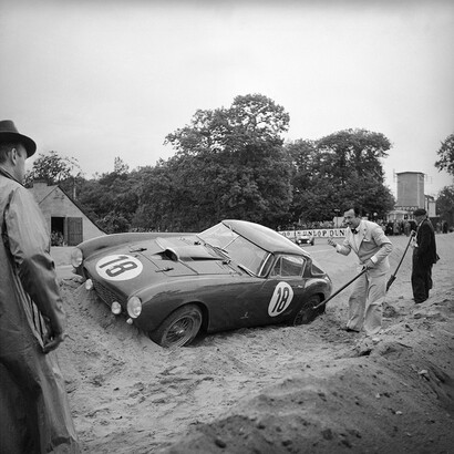 Such is Life in Racing – Le Mans 1954 portrays an unfortunate incident in which Italy’s Count Innocente Biaggio and Dominican playboy Porfirio Rubirosa raced a Ferrari 375 MM no. 18. Speeding around the famed Mulsanne corner of the 24 Hours of Le Mans, the car uncontrollably spun out into the sand banks. Biaggio was determined to get back on the track by digging out the Ferrari even while sporting a light grey Alpaca suit, silk shirt, and black bowtie – true class!