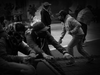 Hombres cargan una reja en una protesta durante el paro nacional indígena de 2022 en Ecuador