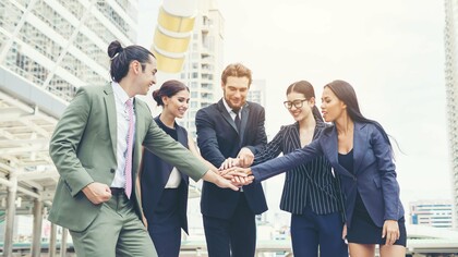 A collaborative team expressing solidarity through joined hands, symbolising the value of collective commitment