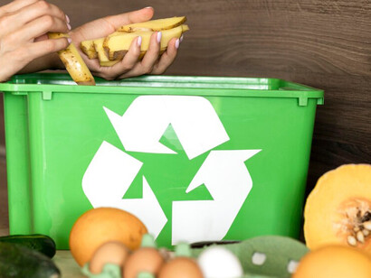 An individual recycling organic vegetable scraps using a composting basket to promote sustainable waste management