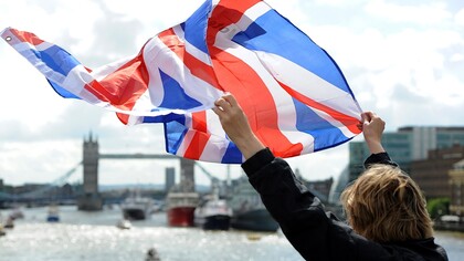 Saludando con una bandera británica sobre el Támesis