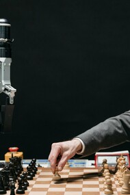 Un homme joue aux échecs avec une machine représentant une lutte entre l'intelligence humaine et l'intelligence artificielle