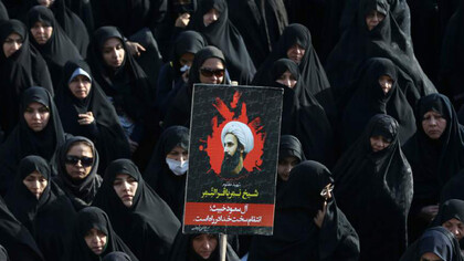 An Iranian woman holds up a poster showing Sheikh Nimr al-Nimr, a prominent opposition Saudi Shiite cleric who was executed last week by Saudi Arabia