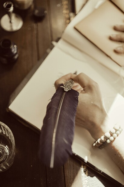 Mulher escreve com tinta e pluma