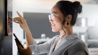 A smart home wall system, along with a smartphone, empowers a woman to monitor and control various aspects of house automation, including air conditioning and security networks