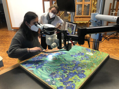 Former Getty intern Michelle Tenggara and Paintings Conservator Devi Ormond examine the surface of the painting under magnification. b