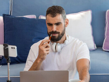 A man working from home with a laptop, vlogging as a social media influencer