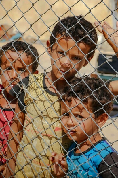 Children observe onlooker through a fence