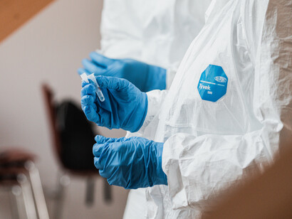 Profesional sanitario manipula una muestra dentro de un recipiente durante un procedimiento médico