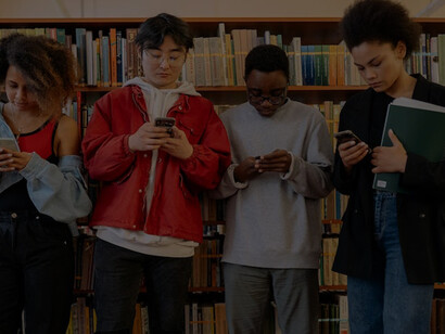Youngsters in the library, engrossed in their smartphones