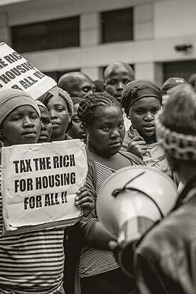 Protesters hold signs in Cape Town, South Africa, 2012