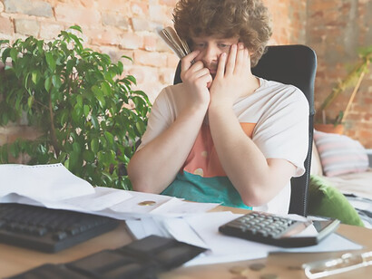 Evocative portrayal of a distressed man gazing at financial and economic graphs during daylight hours, expressing feelings of unsettlement and despair