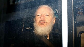 Assange a bordo del furgone della polizia durante l'arresto