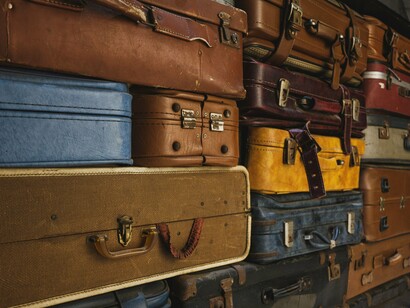 Malas antigas empilhadas em um ambiente rústico remetem à preparação para uma viagem e à expectativa pelo que está por vir. Antes de conhecer um lugar diferente, é preciso deixar para trás, ainda que temporariamente, aquilo que nos é familiar