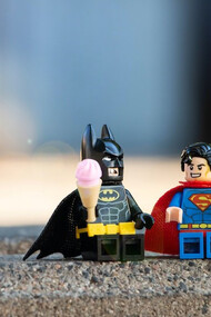 Superman and Batman action figures joined in friendship, holding hands