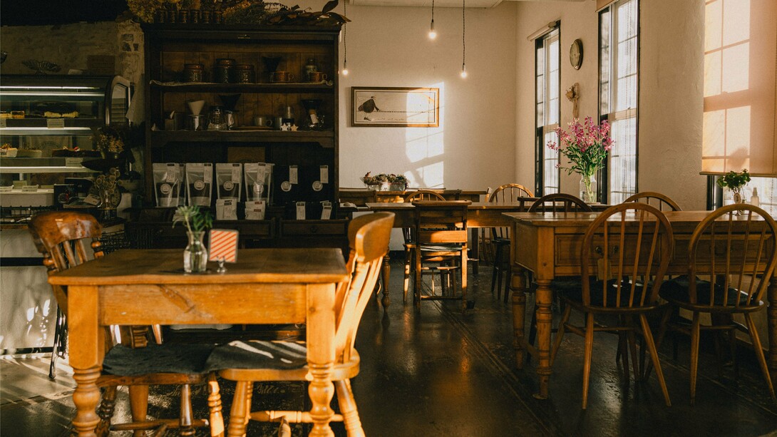 A warm, vintage café interior bathed in natural light, representing the charm and elegance of Japan's traditional kissaten culture