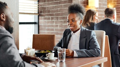 Mulher veste camisa branca e blazer em cor neutra para entrevista de emprego
