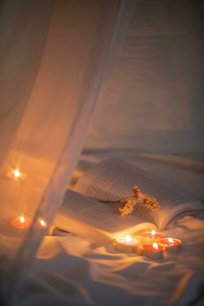 Libro, velas y flores. La petite mort es una expresión poética que evoca un estado de éxtasis