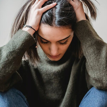 Girl in green sweater looking depressed