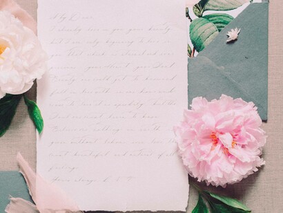 A love letter handwritten with flowers by its side