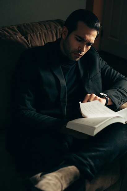 A man reading a book on a sofa. Being rich is finding what fulfils us