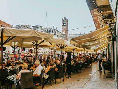 Crowded sidewalk cafés in a town square in Verona, Veneto, Italy
