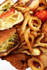 A man opens his mouth wide to over eat a lot of junk food