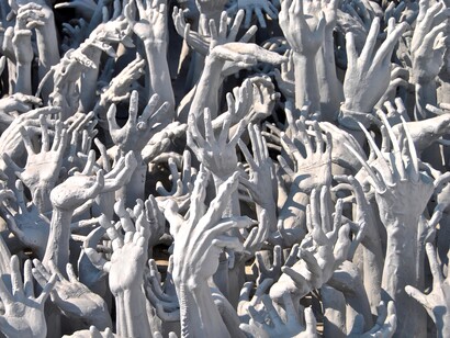 Chiang Rai, Tailandia. Manos de los sufrientes en la entrada al Templo Blanco