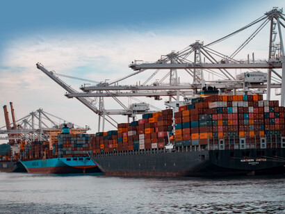 Freight containers stacked on cargo ships docked at the pier, symbolizing global trade routes, strategic partnerships, and the India-Middle East-Europe Economic Corridor's role in economic diplomacy