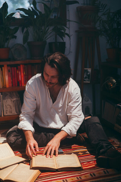 A man reading poetry on a vintage red carpet