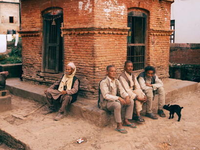 A poignant scene by the roadside captures elderly individuals, reflecting the stark reality of global inequality and societal neglect amidst burgeoning environmental and social crises