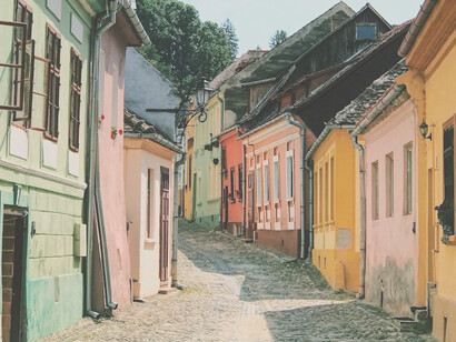 Vibrant hues adorn the houses lining the streets of Sighișoara, Romania, adding a burst of color to its charming medieval architecture