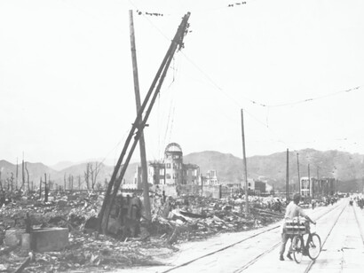 A man pushes his bicycle through the streets  after the atomic bomb destroyed Hiroshima, Japan in 1945