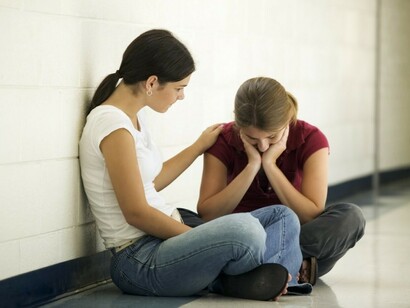 Una chica consuela a otra tras la pérdida de un ser querido