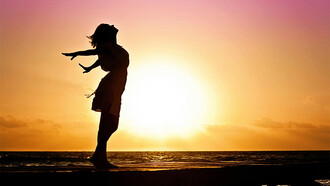 Mulher no pôr do sol. Marina, a menina do mar, namora o céu e sente as estrelas
